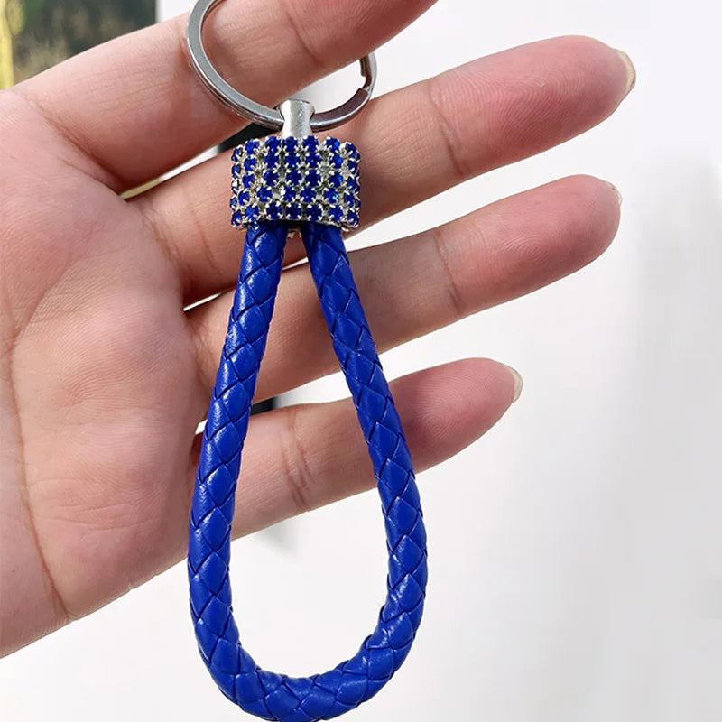Cute rhinestone bear keychain with blue braided strap and sparkling rhinestone detail held in hand