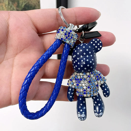 Blue cute rhinestone bear keychain with braided strap held in hand by DFShop