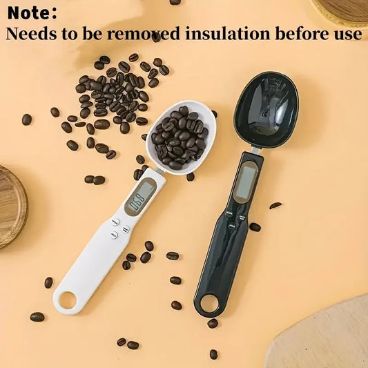 White and black digital measuring spoon scale with coffee beans on a beige surface from DFShop