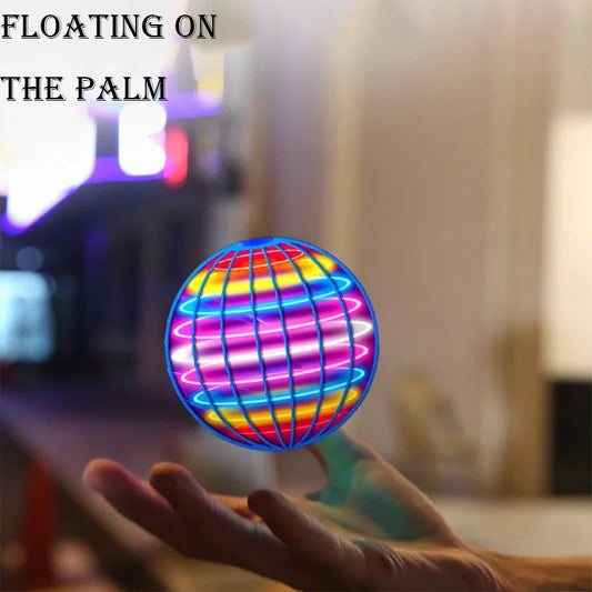 Colorful flying orb ball toy floating above an open palm in a blurred indoor setting