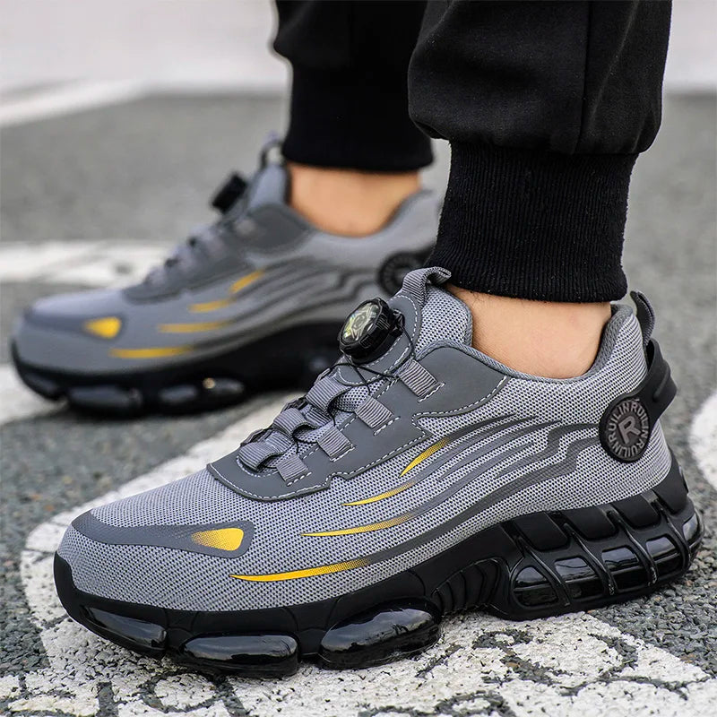 Gray and black anti puncture non slip work boots with yellow accents worn outdoors
