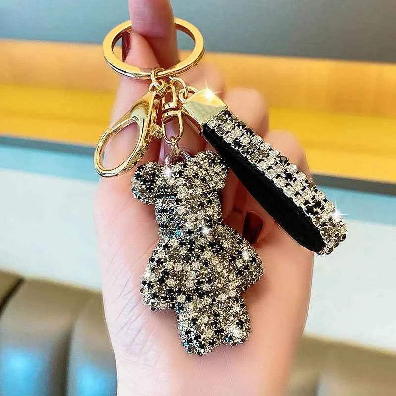 Glittering rhinestone bear keychain with black and silver crystals held in hand by DFShop