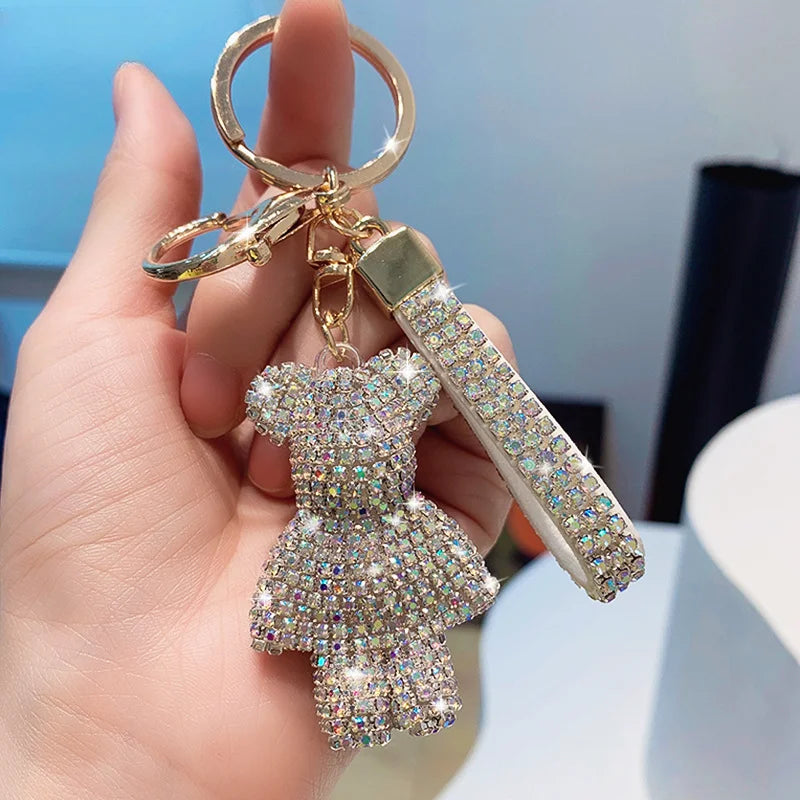 Hand holding a shiny rhinestone bear keychain with sparkling crystals and gold hardware