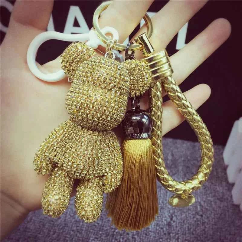 Gold rhinestone bear keychain with braided strap and tassel held in hand by DFShop
