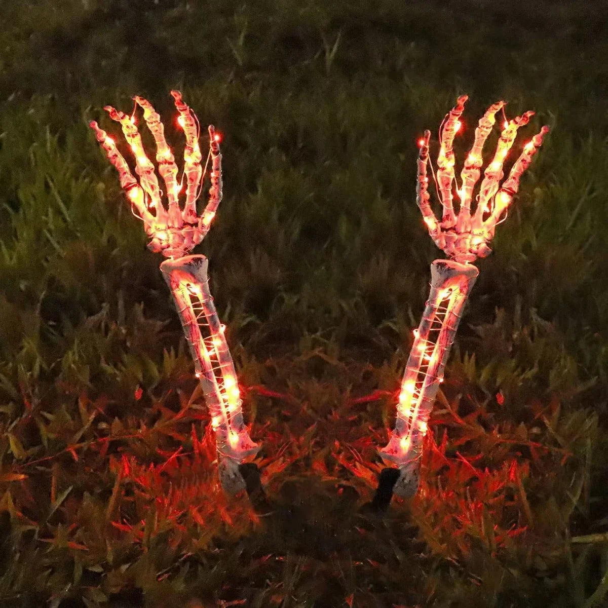 Halloween ghost hand lights glowing orange skeleton hands lighting up grass at night