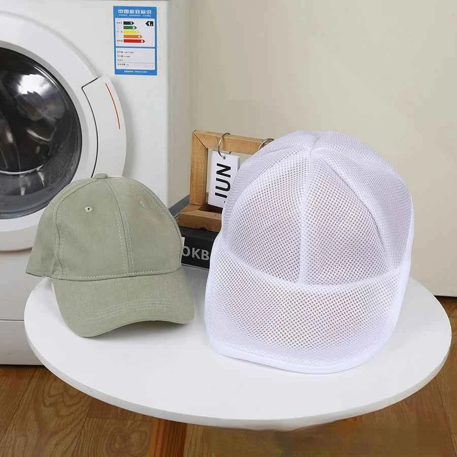 White mesh anti deformation cap protector next to green baseball cap on white round table