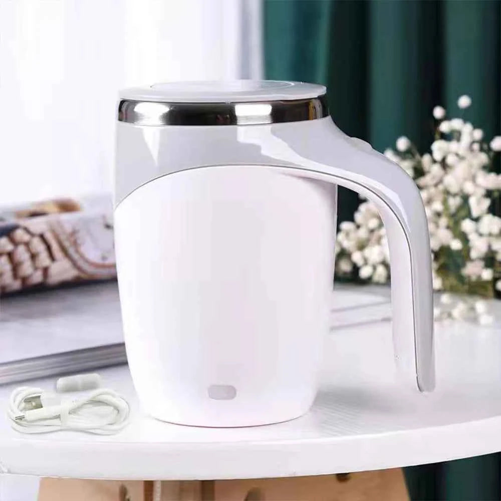 White automatic self stirring coffee mug with silver rim and ergonomic handle on table
