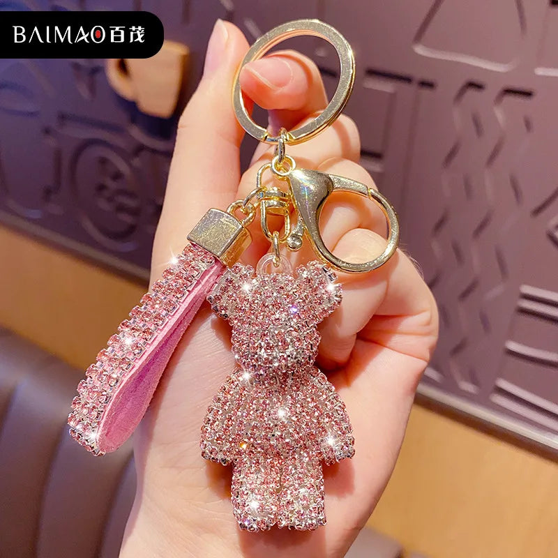 Shiny pink rhinestone bear keychain with a matching rhinestone strap held in hand