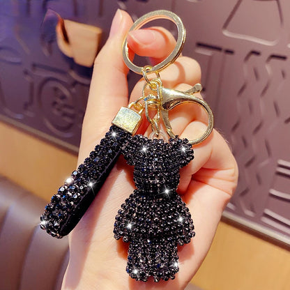 Black rhinestone bear keychain with sparkling crystals and gold key ring held in hand