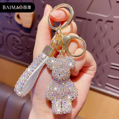 Shiny rhinestone bear keychain with a sparkling strap and gold-colored clasp held in hand