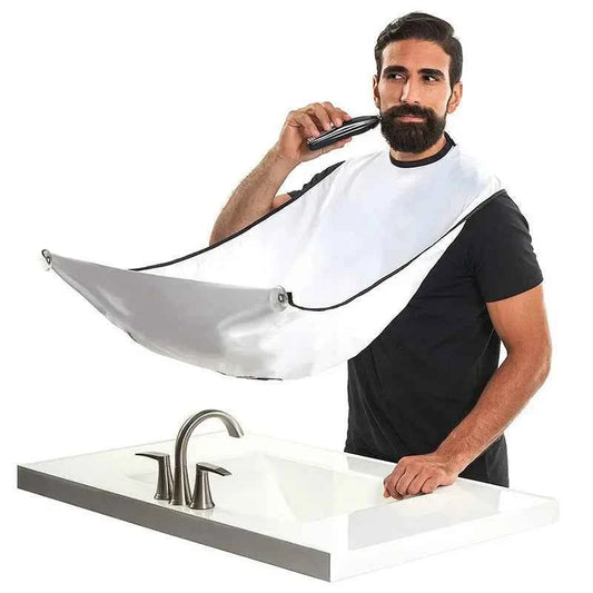 Man wearing beard trimming bib for men in white while grooming beard over bathroom sink