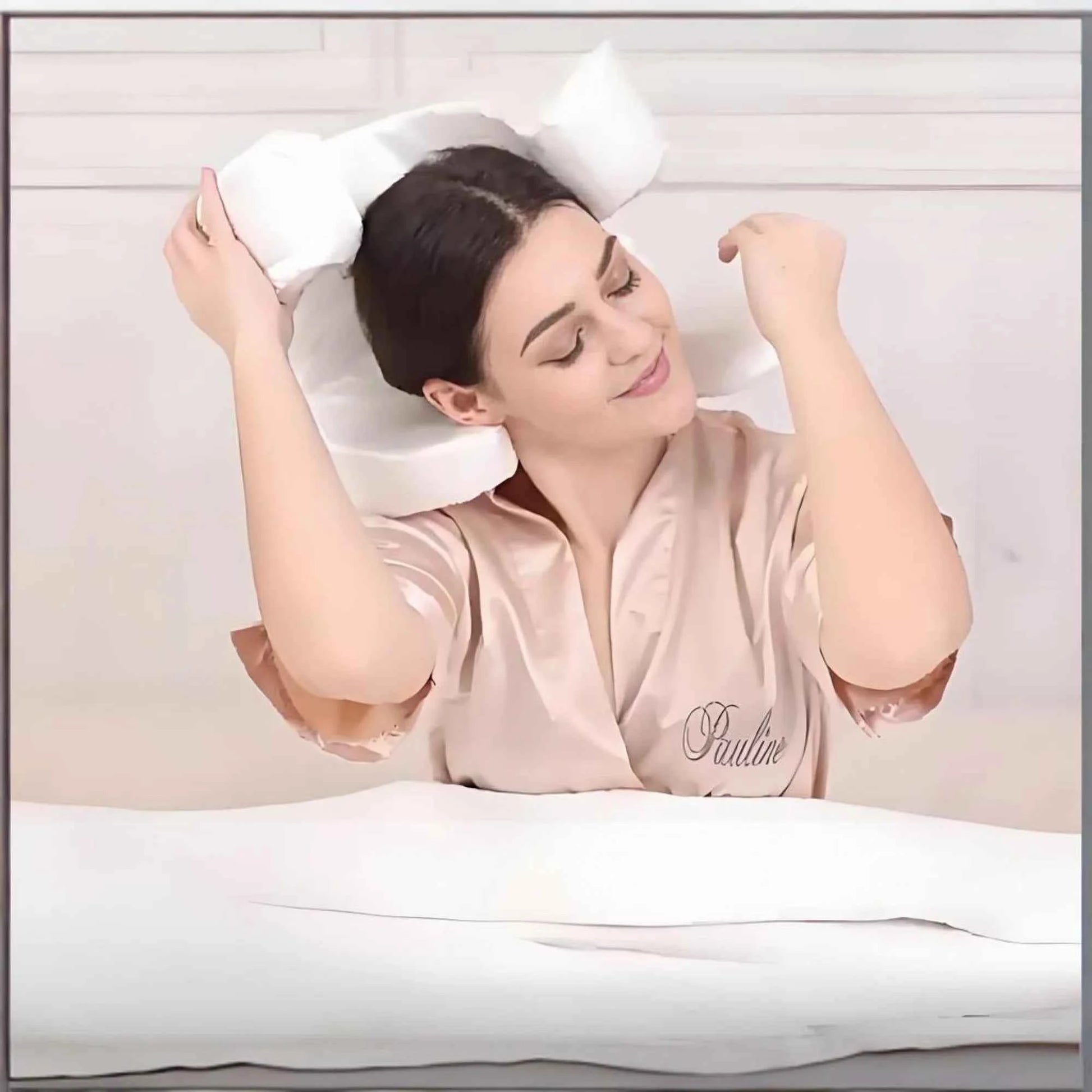 Woman in satin robe using white anti wrinkle sleep pillow for comfortable head support