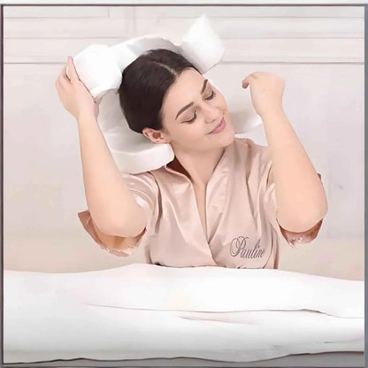 Woman in satin robe using white anti wrinkle sleep pillow for comfortable head support