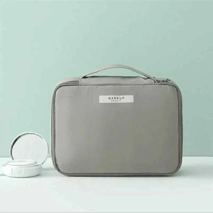 Gray portable cosmetic organizer with handle and zip closure by DFShop displayed with compact makeup case