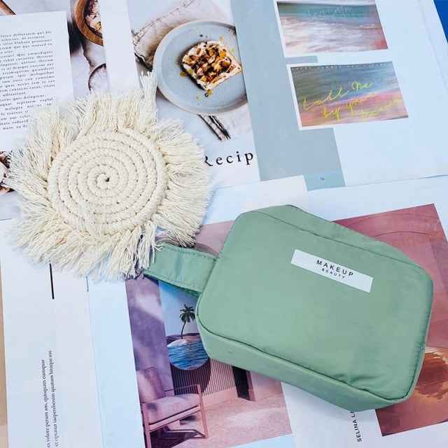 Green DFShop portable cosmetic organizer with handle on magazine background