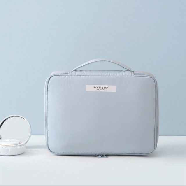Light blue portable cosmetic organizer with handle and zip closure by DFShop on white surface