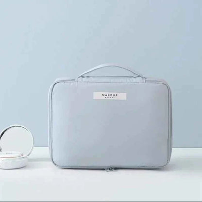 Light gray portable cosmetic organizer with handle and zip closure by DFShop on light background