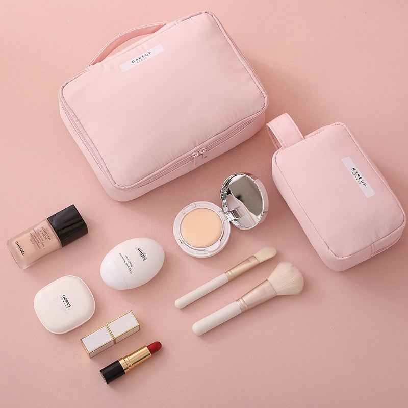 Pink portable cosmetic organizer set with two bags, makeup brushes, foundation, lipstick, and compact powder
