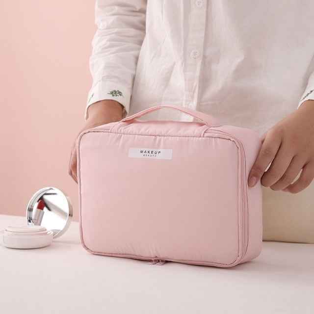 Pink portable cosmetic organizer from DFShop being held by a person with makeup items nearby