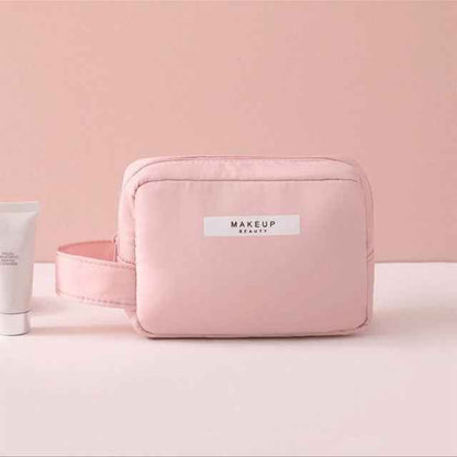 Pink portable cosmetic organizer bag with handle and makeup label on front