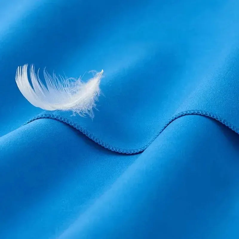 Close-up of DFShop quick drying sports towel in bright blue with soft white feather on fabric