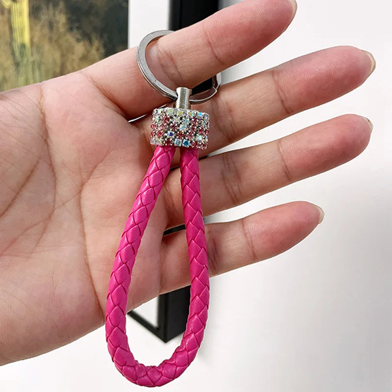 Cute rhinestone bear keychain with pink braided loop held in hand for stylish accessory