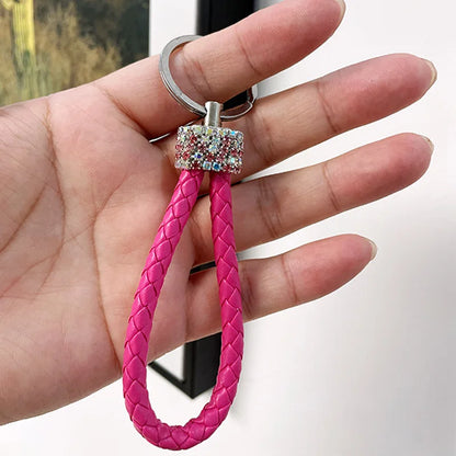 Cute rhinestone bear keychain with pink braided loop held in hand for stylish accessory