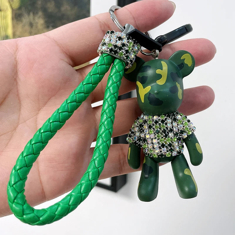 Cute rhinestone bear keychain with green camo design and braided green strap held in hand