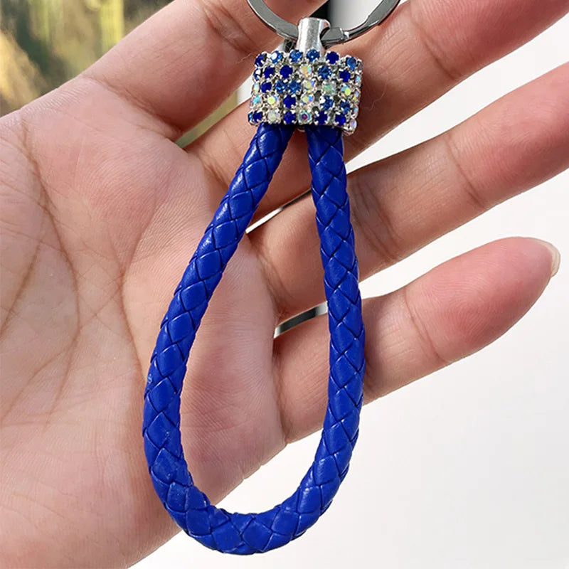 Cute rhinestone bear keychain with blue braided loop and sparkling rhinestone detail held in hand