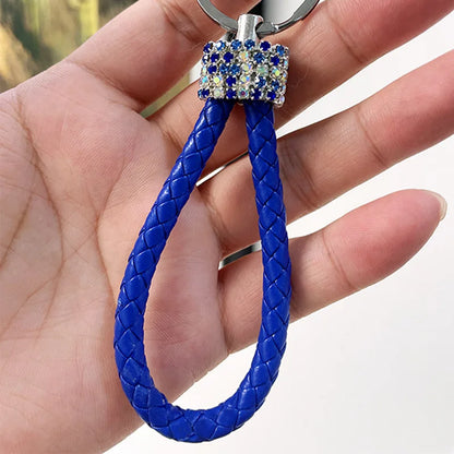 Cute rhinestone bear keychain with blue braided loop and sparkling rhinestone detail held in hand