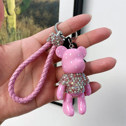 Cute rhinestone bear keychain in pink with polka dots and braided strap held in hand