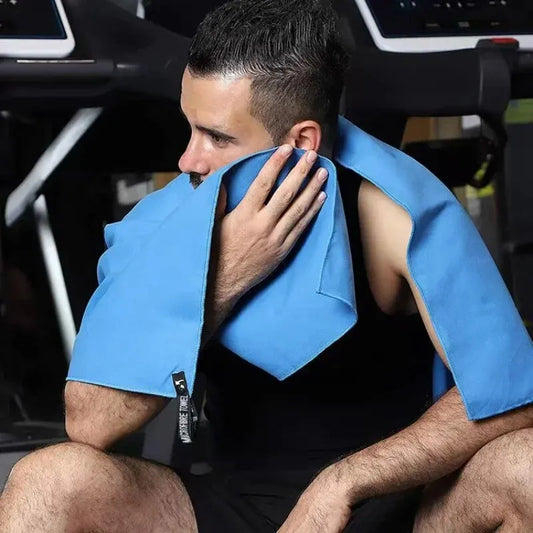 Man using a blue quick drying sports towel on his neck during gym workout to wipe sweat