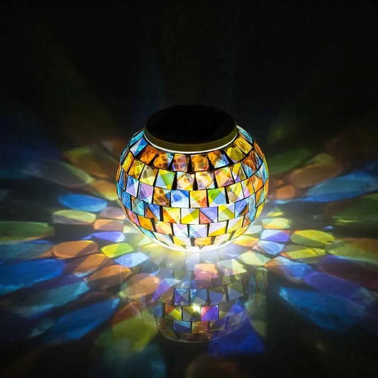 Colorful solar mosaic garden lights glowing in dark with vibrant blue yellow and orange glass pieces