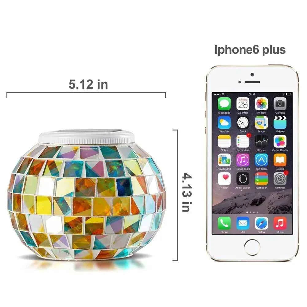 Colorful solar mosaic garden lights in a spherical shape next to an iPhone 6 Plus for size comparison