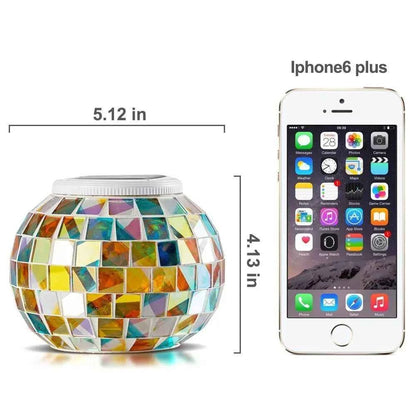 Colorful solar mosaic garden lights in a spherical shape next to an iPhone 6 Plus for size comparison