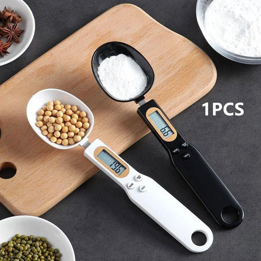 Black and white digital measuring spoon scale with LCD display measuring powder and beans on wooden board