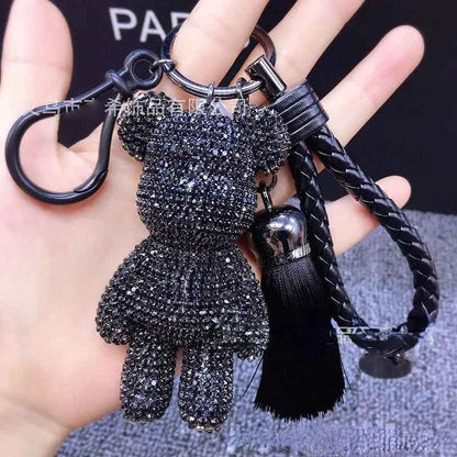 Black rhinestone bear keychain with braided strap and tassel held in hand by DFShop
