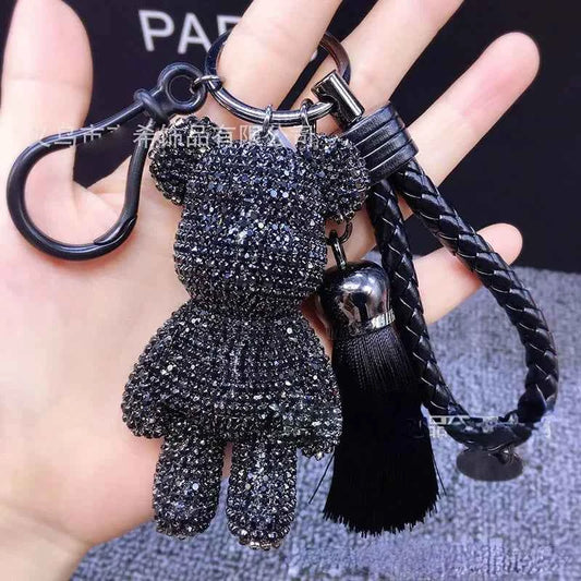 Black rhinestone bear keychain with braided strap and tassel held in hand by DFShop