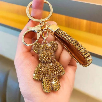 Gold rhinestone bear keychain with matching wrist strap and metal ring held in hand