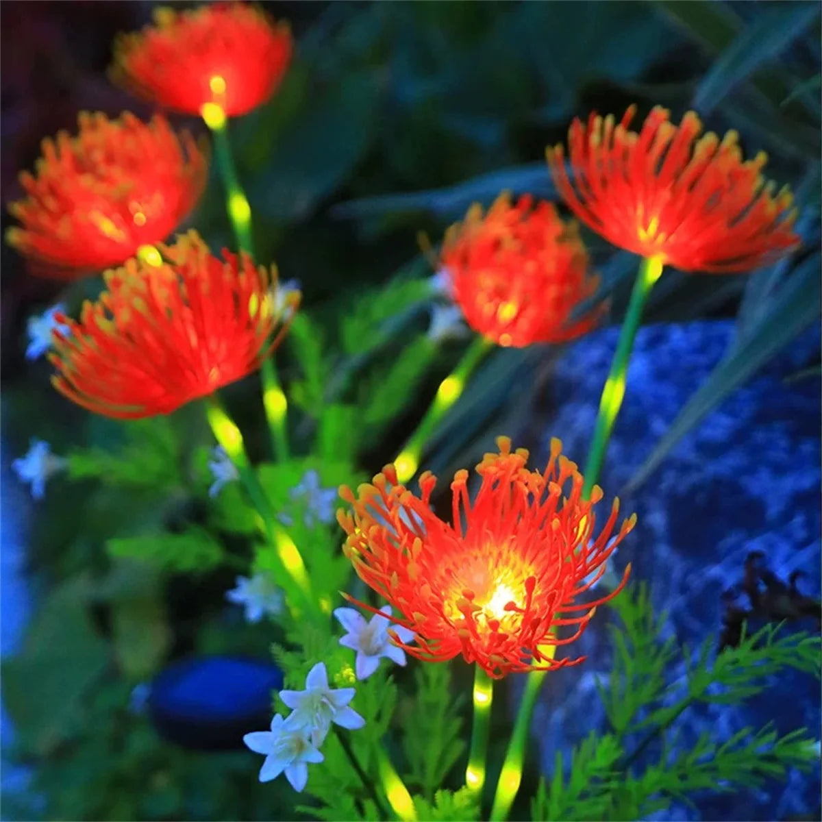 DFShop solar flower garden lights glowing orange in a nighttime garden setting with green stems and small white flowers