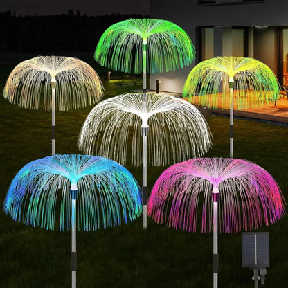 Colorful solar jellyfish garden lights glowing in various colors on a lawn at night