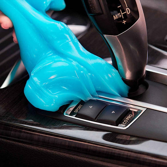 Blue car cleaning gel molding around car gear shift and buttons to remove dust and debris